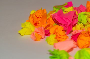 Bright crumpled multi-colored stickers on the office white board.