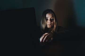 Teen girl excessively sitting at the computer laptop at home. he is a victim of online bullying...