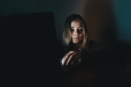 Teen girl excessively sitting at the computer laptop at home. he is a victim of online bullying Stalker social networks.Too much work sleepy stressed young woman