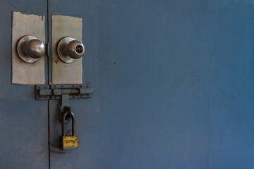 Closing gate of secret area. Brass padlock was locked the old light blue metal door, Selective focus and copy space, Processed in vintage style