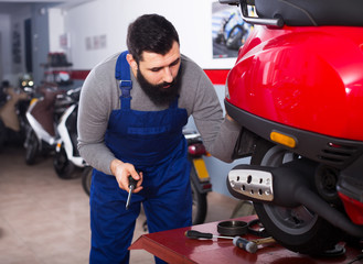 Worker inspects the motorcycle for damage