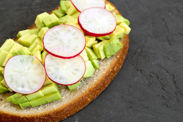 Rye bread with avocado on grey background.