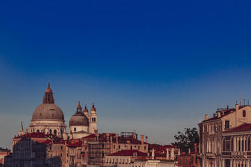 Fototapeta na wymiar Basilica of Santa Maria della Salute and Venetian houses under blue sky at sunset, in Venice, Italy