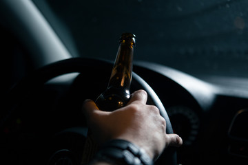 Drunk driver. Man drinking beer while driving a car