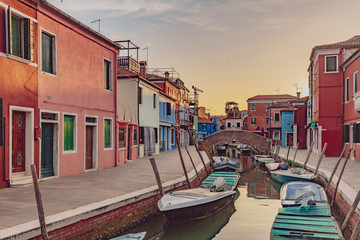 Fototapeta na wymiar Colorful houses and streets by canal on the island of Burano, Venice, Italy, at sunset