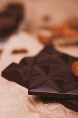 Black chocolate close-up on a light background. Coffee, chocolate on paper.