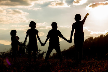 Fototapeta na wymiar Silhouette group children looking sunset on mountain