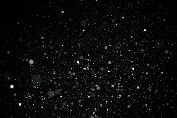 Falling snow on black background.