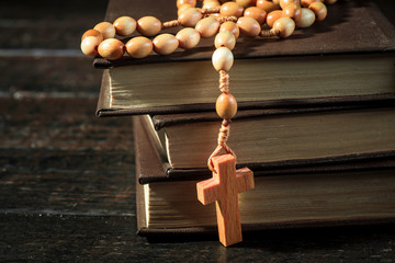 Rosary on the background of books