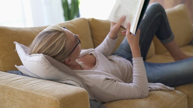 Middle-aged woman at home reading book