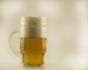 Filled with beer glass with white foam on a white isolated background