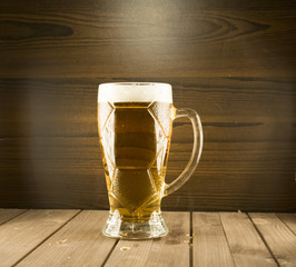 Filled with beer glass with white foam on the background of wooden boards