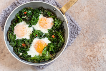 Fried eggs kale green leaves for breakfast