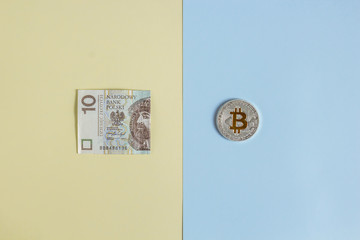 Bitcoins and Zloty on a pastel background, the concept of confrontation between cryptocurrency and paper money