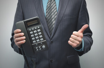 Telephone and phone handset in the businessman hands isolated on the white background.