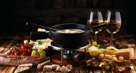 Fototapete Gourmet Swiss fondue dinner on a winter evening with assorted cheese © beats_