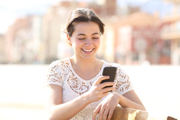 Happy lady uses a smartphone in a park