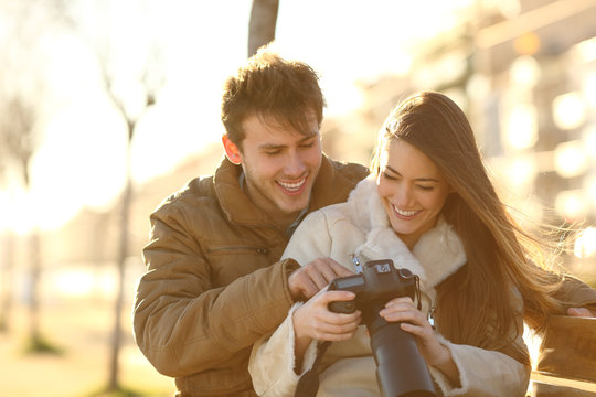 Happy couple checking photos on a dslr camera