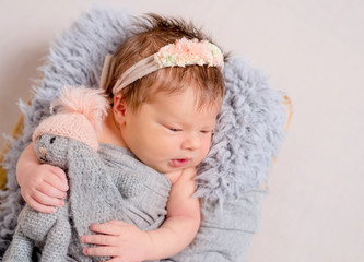 Cute little baby with knitted toy bunny lying