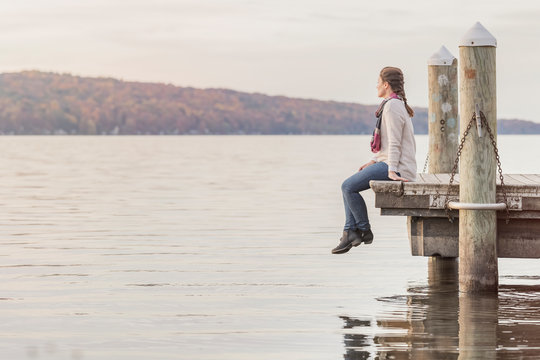 Woman sitting on the pier at the lake