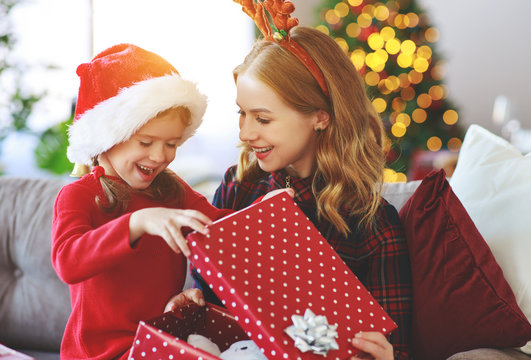 family   mother and child daughter open presents on Christmas morning