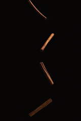 Cinnamon sticks falling on black background. Food for food. cinnamon in motion. isolate