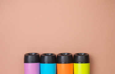 Multicolored thermo mugs on the brown background with copy space