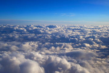 Naklejka na ściany i meble over cumulus clouds bright landscape view from the window of an airplane