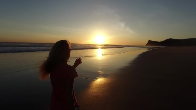 Woman walking along the beach at sunset Playa Colorado, Tola Nicaragua
