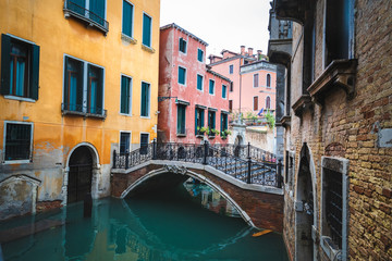 Fototapeta na wymiar Kanal mit Brücke und bunten Häusern in Venedig