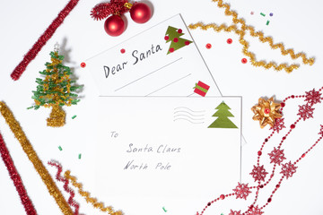 letter of white paper and a white envelope to Santa Claus on a white background, around the Christmas decorations