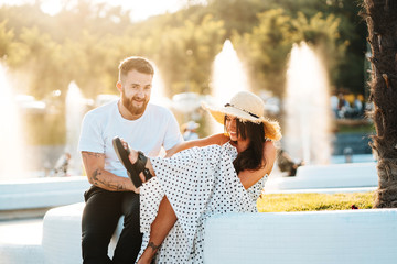 Handsome bearded man and his beautiful girl resting near fountains