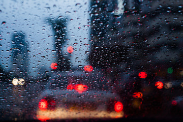 wet car windshield during rainy weather blured traffic light