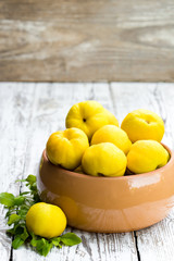Fresh quince fruits on white wooden table