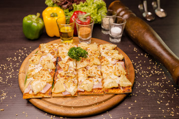Home made Pizza Hawaiian served on wooden texture plates