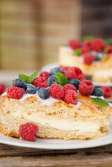 Homemade cheesecake with fresh berries and mint for dessert - healthy organic summer dessert pie cheesecake.