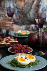 A light summer dinner for two: boiled eggs with arugula and avocado, raspberries for dessert, purple pears and white wine.