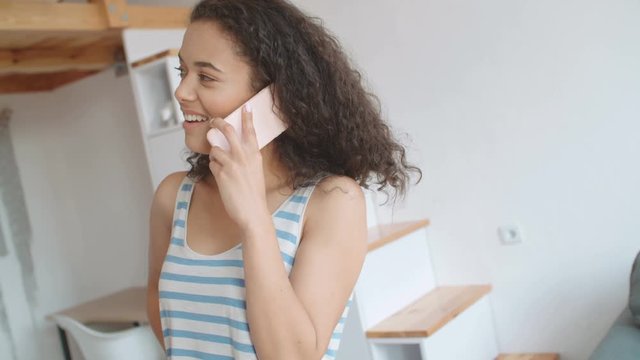 Young woman talking on mobile phone in stylish apartment.