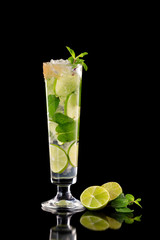 Closeup glass of fresh mojito cocktail with mint and lime isolated at black background.