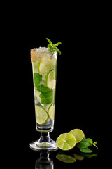 Closeup glass of fresh mojito cocktail with mint and lime isolated at black background.
