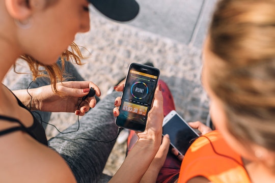 Young women using running app in smartphone