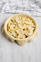 Preparation of apple pie on a white wooden background, low angle view. Close-up.
