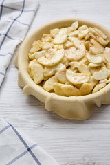 Preparation of apple pie on a white wooden background, side view. Close-up.