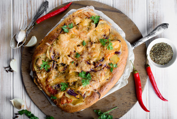 Delicious and appetizing pizza from yeast dough. Delicious and healthy vegetable pizza. Vegetable pizza on a white wooden table.