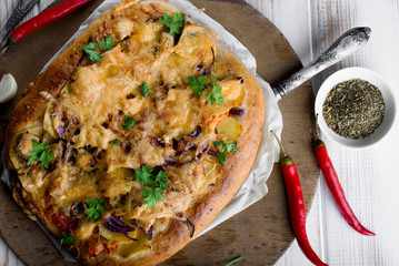 Delicious and appetizing pizza from yeast dough. Delicious and healthy vegetable pizza. Vegetable pizza on a white wooden table.