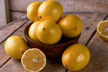 Fresh Juicy Lemon cut on wooden table, close-up. 