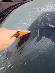 Hand scratching ice from car window