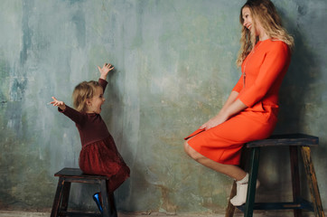 Fototapeta na wymiar Young woman and little girl in same dresses having fun