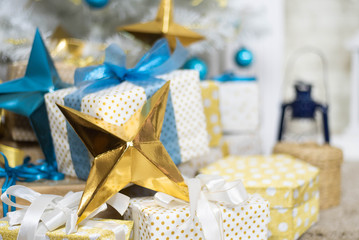 family holiday concept. Merry Christmas and Happy Holidays. Studio with Christmas decor. Winter home decor. Christmas tree, fireplace with firewood Boxes with gifts and golden and blue bows. Xmas