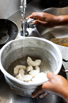 Person filling up a bowl of cassava root with water